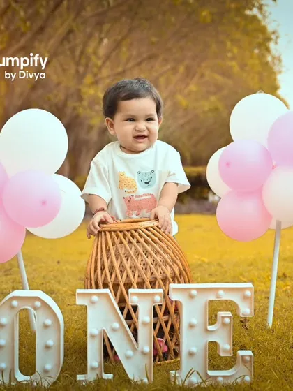 Celebrating one in the great outdoors. This setup combines a fun hot air balloon prop with the beauty of a sunlit park for a unique first birthday shoot.