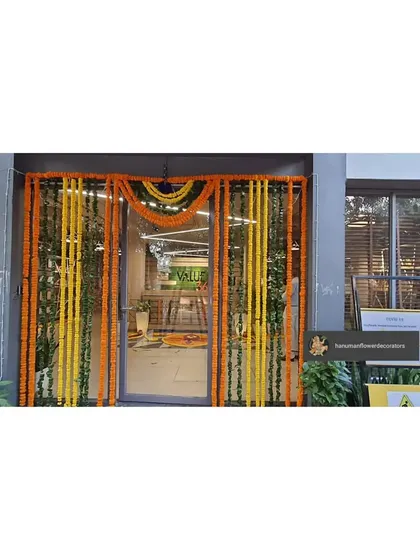 For this corporate office, we decorated the main glass entrance with long strings of yellow and orange marigolds. This is a classic and vibrant way to mark a festive occasion like Diwali.
