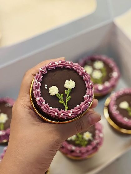 A close-up of another style of hand-piped flower on these chocolate cupcakes. Each one is slightly different and made with care.