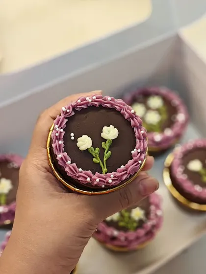 A close-up of another style of hand-piped flower on these chocolate cupcakes. Each one is slightly different and made with care.