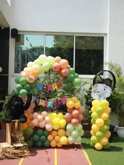 The central photo spot for a jungle birthday, with a colorful balloon arch and a "Happy Birthday" banner. A friendly gorilla plushie adds a fun touch for the kids.
