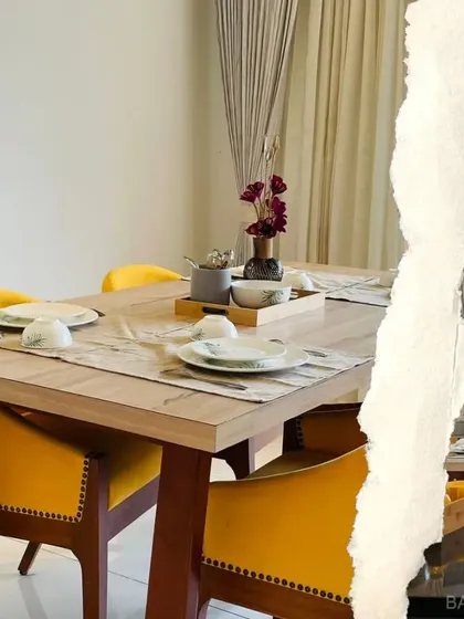 A close-up of the dining table, where bold yellow chairs add a cheerful and energetic vibe to the room.