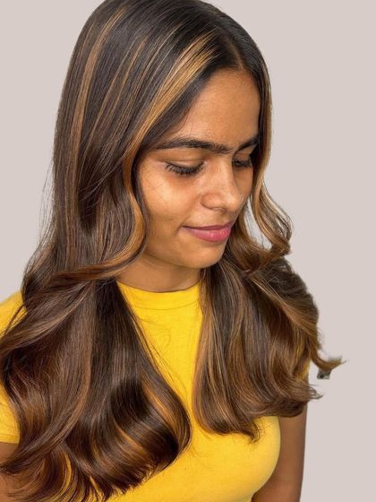 A side profile of the Brown Sugar hair color, showing how the face framing highlights and warm tones complement the client's skin. This look is all about creating a warm and inviting style.