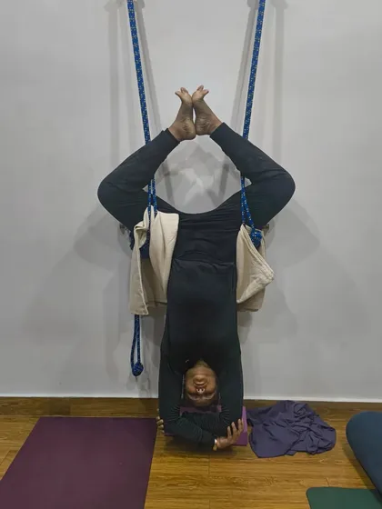 Sometimes it's a good idea to go upside down and clear your head. A student enjoying a supported headstand with the help of the ropes.