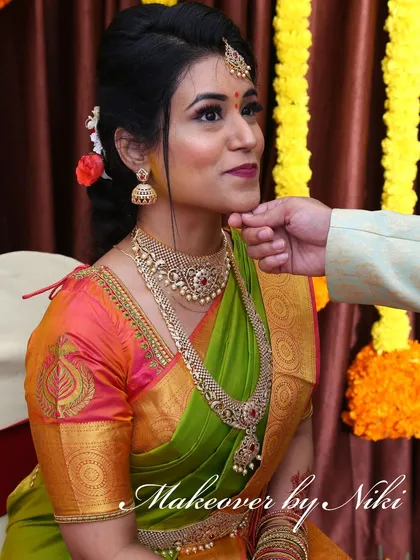 A complete look at Nirosha's engagement style. She wore a vibrant silk saree, and we created a soft glam look with a pretty pink lip and a chic updo.