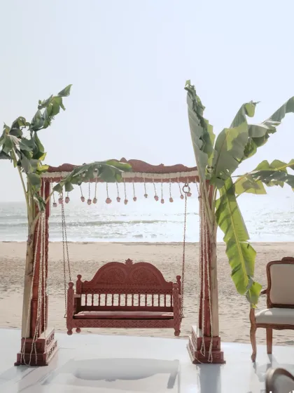A traditional swing or 'oonjal' ceremony setup on the beaches of Goa. We incorporated authentic elements like banana leaves and a carved wooden swing to honour the couple's South Indian roots.