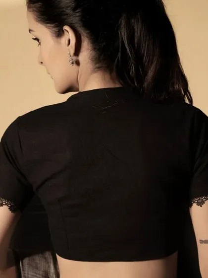 The back of our black lace-detailed blouse. The simple, elegant cut ensures the focus remains on the beautiful fabric and the person wearing it.