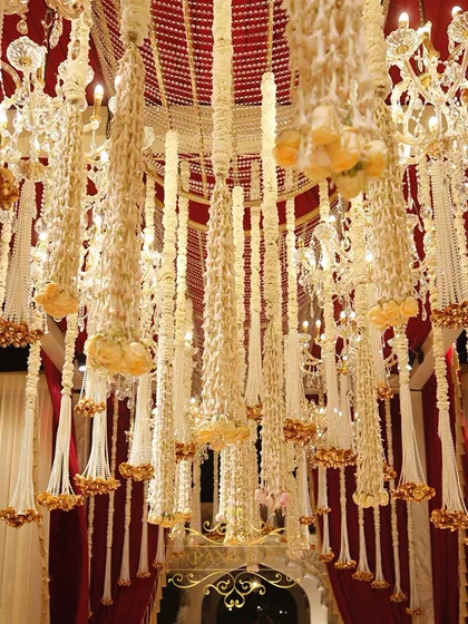 A detailed shot of the ceiling treatment, featuring cascading tassels made of fragrant Rajnigandha and pearls. This adds a layer of texture and traditional elegance to the venue.