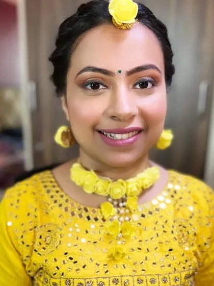 My bride Pooja, glowing for her Haldi ceremony. The yellow floral jewelry and soft, shimmery makeup create a look that is both traditional and fresh.