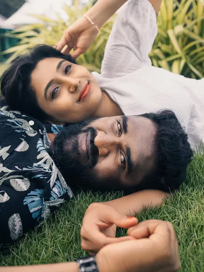 An intimate overhead shot of the couple lying on the grass, creating a unique and personal portrait.