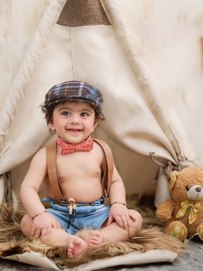 A happy camper ready for an adventure. This teepee setup with a friendly teddy bear is a classic and beloved theme for baby portraits.