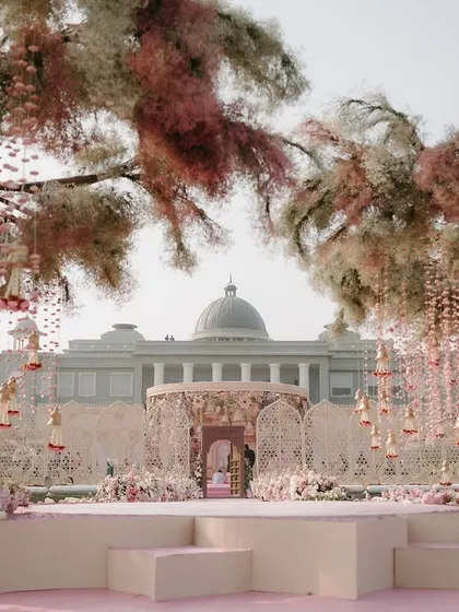 A stage view of the whimsical mandap, with its floral-covered trees and hanging kaleeras. This setup shows our ability to create a fantasy world for your special day.
