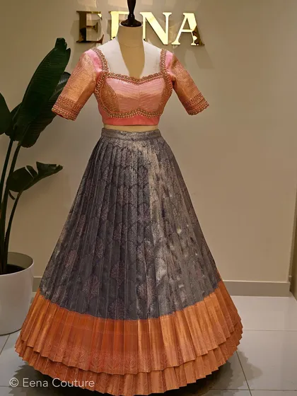 For bride Sneha's welcoming ceremony, I designed this unique two-tier lehenga. The elegant combination of grey and pink, paired with a hand-embroidered blouse, created an ethereal and memorable look.