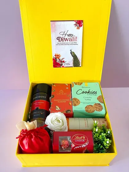 A bright and cheerful Diwali hamper in a yellow box. This one is packed with coffee, cookies, chocolates, and incense.