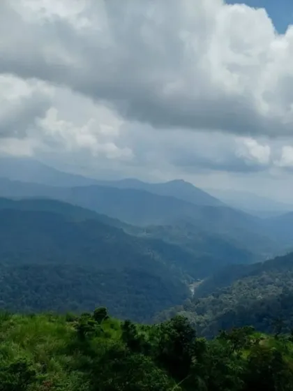 The layered hills of the Western Ghats as seen from Devaramane Betta, offering a breathtaking panoramic view.