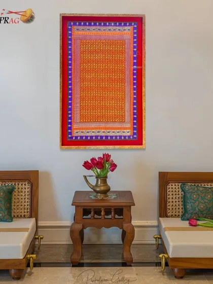 A vibrant textile piece, framed to become a statement artwork that brings color and traditional craftsmanship into a modern space.