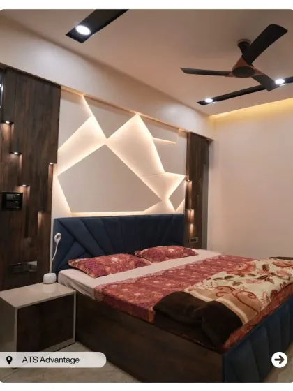 A striking bedroom with a geometric, backlit headboard wall. The design uses sharp angles and light to create a futuristic and energetic vibe.