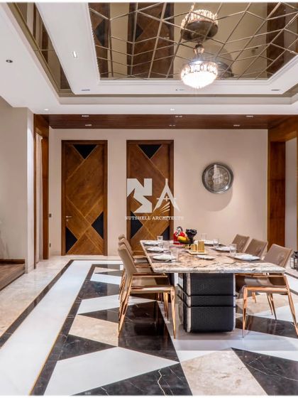 A closer look at the dining lobby, where a geometric black and white stone floor creates a bold foundation. The mirrored ceiling reflects the light and the intricate details of the space, adding depth and a sense of grandeur.