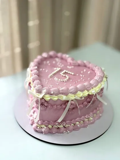 A heart-shaped vintage cake for a 15th birthday, with delicate piping and ribbon details.