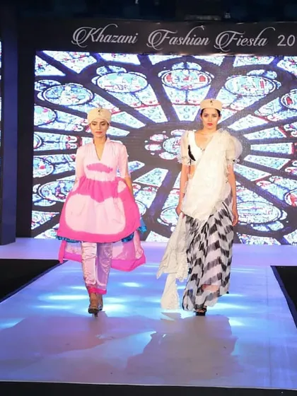 A glimpse from our 2018 fashion show, where students presented their unique designs. The model on the left wears a modern pink tunic over satin pants, while the one on the right showcases a deconstructed saree look with a bold black-and-white print.