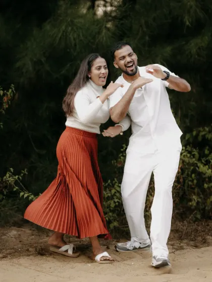 A fun and candid shot of a couple dancing and laughing together, their energy infectious.