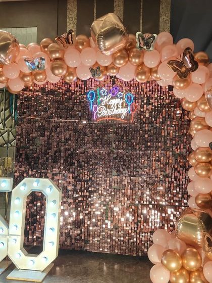Another angle of the elegant 50th birthday decor, showing the shimmer of the sequin wall and the soft colors of the balloon arrangement.