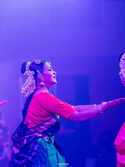 A side profile of a dancer lost in the moment of performance. The stage lights create a beautiful silhouette, emphasizing her expressive form.