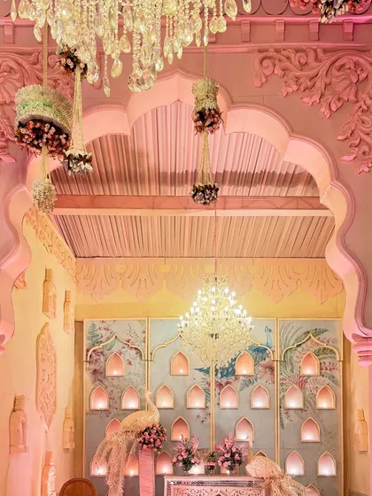 Every corner tells a story in my designs. This nook within a palace set features a beautifully carved arch, peacock motifs, and a wall of niches for diyas, all under the soft glow of a crystal chandelier.