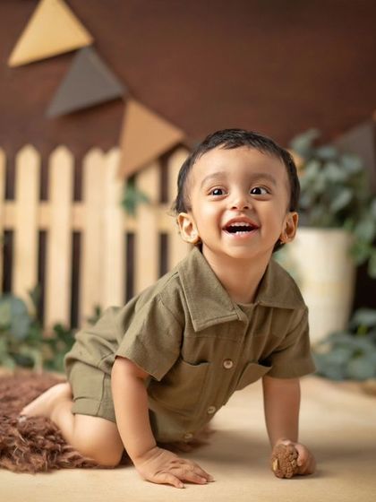 A cute little "range officer" in a rustic, woodland-themed first birthday setup.