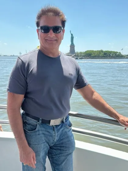 In New York, with the Statue of Liberty in the background. This landmark represents the dreams of many of my clients, and my work is dedicated to helping them achieve their American aspirations legally.