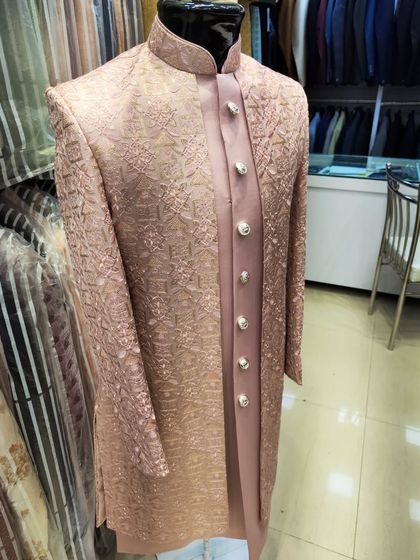A full view of a heavy-embroidered open sherwani in a dusty rose color, displayed on a mannequin to show its structure and design.