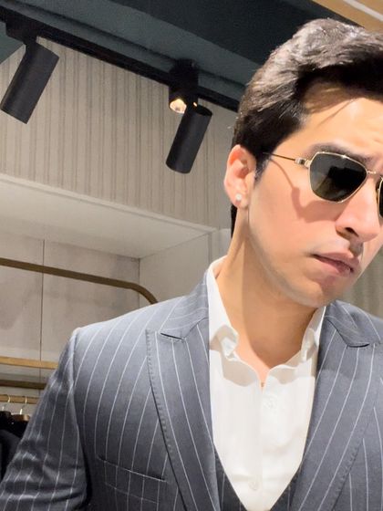 A close-up shot of the pinstripe suit, highlighting the classic pattern and the crisp white shirt pairing. This is a timeless look for any business professional.