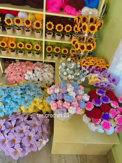 A full view of my product display, with potted sunflowers on the shelves and various bouquets ready for packing.