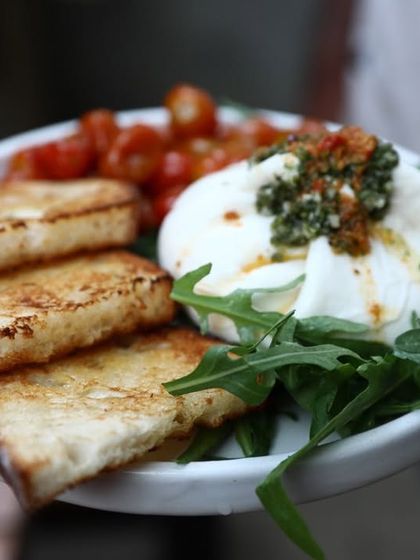 Our house-made burrata served simply with toasted sourdough and roasted cherry tomatoes. It's the perfect way to enjoy the fresh, creamy flavor of the cheese.