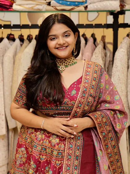 A close-up of the pink printed lehenga, showing the beautiful details and the happy client.