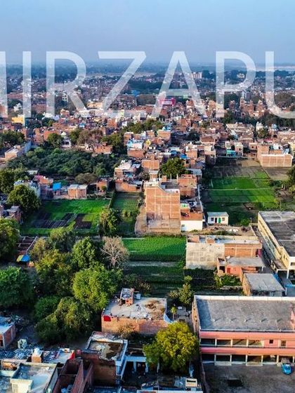 A daytime aerial shot of Mirzapur, showing the mix of buildings and green spaces that make up my city.