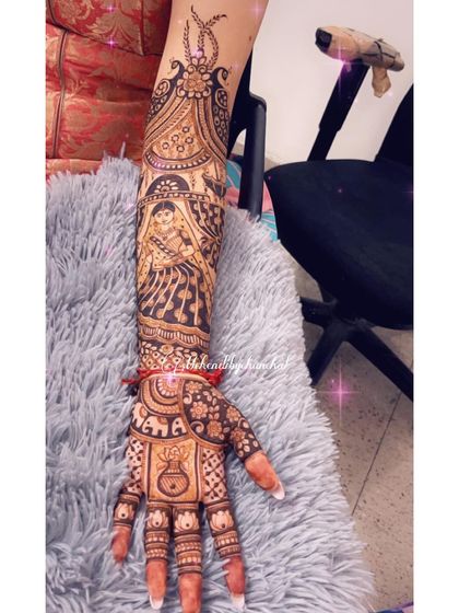 The other arm of the bridal design, featuring a portrait of the bride in her doli (palanquin). Her parents' initials, 'MAMA', are lovingly included on the palm.