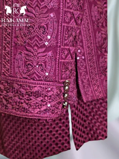 A close-up of the side-slit and buttons on the magenta Jodhpuri, a small detail that enhances the overall design.