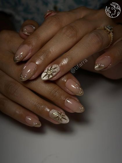 Dazzling divinity. Gel extensions featuring a white cat-eye base with a 3D golden starburst and delicate gold chrome French tips.
