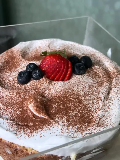 A close-up of our classic Tiramisu, showing the creamy mascarpone layer and dusting of cocoa powder. We also offer a Tres Leches cake, another one of our signature desserts.