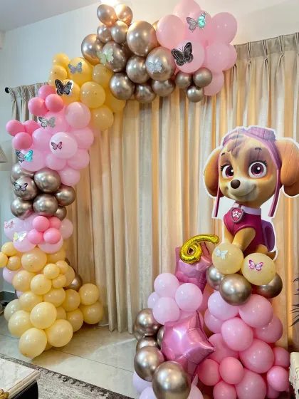 A Paw Patrol Skye-themed 6th birthday. This home setup features a beautiful balloon arch in shades of pink, yellow, and chrome, with a large cutout of Skye.