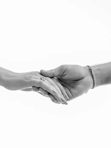 Sometimes, the simplest image is the most profound. This minimalist black and white shot of hands connecting is a beautiful, symbolic representation of a couple's bond.