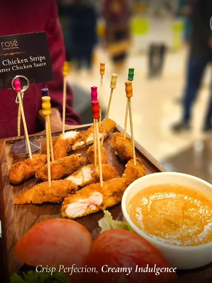 A close-up of our Crispy Chicken Strips with Butter Chicken Sauce. This fusion dish perfectly balances a crunchy exterior with a rich, creamy dip, offering a unique and indulgent appetizer.