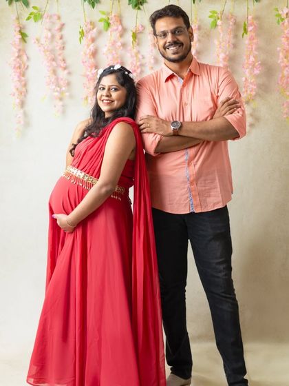 A classic pose for a couple's maternity shoot. The partner stands beside the expecting mother, creating a portrait that speaks of support and shared excitement.