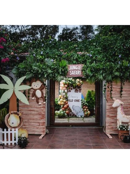 Welcome to the jungle. This entrance uses natural wood textures, lush greenery, and cute animal cutouts like a lion, monkey, and giraffe to set the stage for a wild adventure.