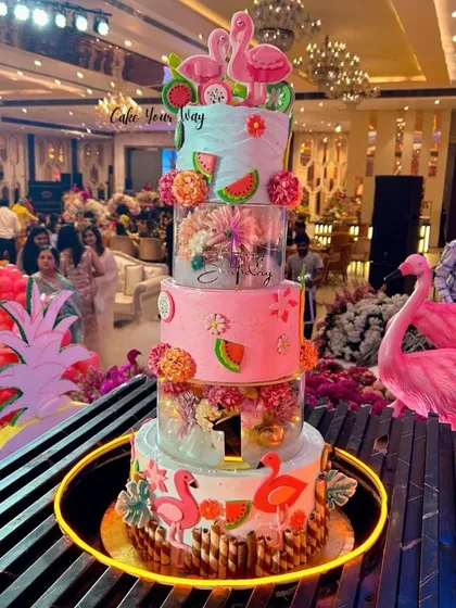 A grand three-tiered flamingo-themed cake for a first birthday party. This was an absolute showstopper.