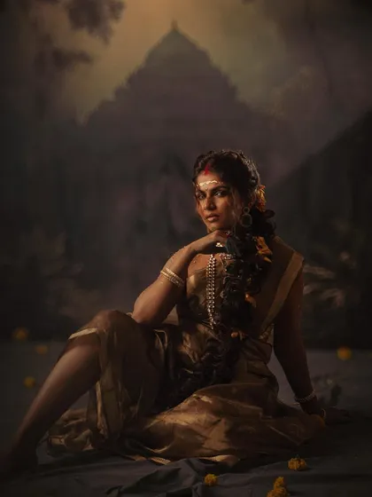 This is from a conceptual shoot titled 'सुवर्ण कांता' (Golden Grace). The styling here is more dramatic and artistic, using a simple tissue saree and bold makeup to tell a story of raw, empowered femininity against a mythical backdrop.