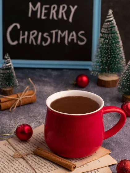 A cozy cup of hot chocolate from our archives, styled with cinnamon sticks and Christmas ornaments for a warm, festive feel.