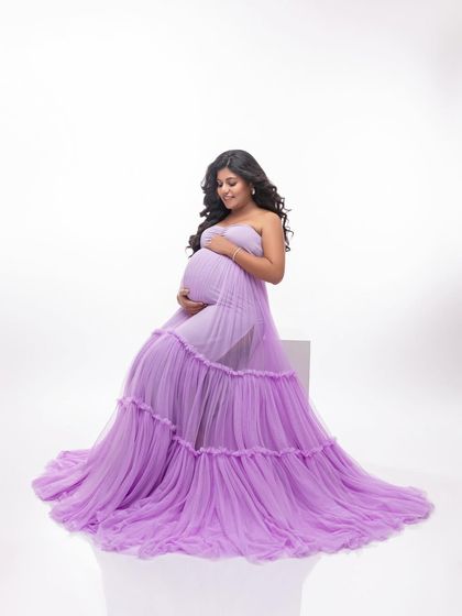 Seated in the lavender gown, the layers of tulle create a beautiful cloud of color around her. This is a dreamy and feminine look.