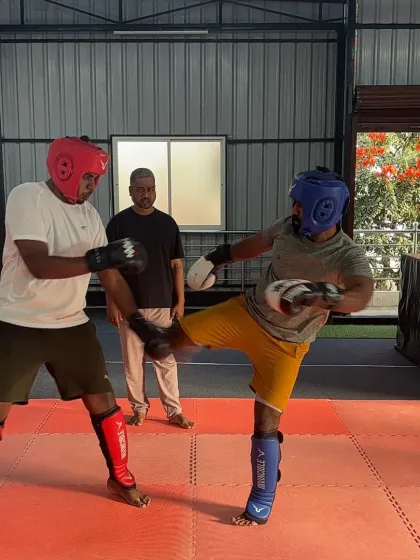 A student practices a defensive block against a kick during an MMA drill. Learning to defend is just as important as learning to attack.